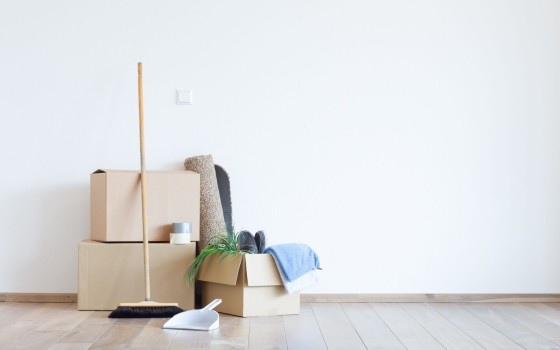 Besen und Kehrblech vor Umzugskartons